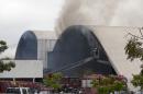 Firefighters watch from a cherry picker as water is sprayed into the Simon Bolivar Auditorium at the Latin America Memorial in Sao Paulo, Brazil, Friday, Nov. 29, 2013. The fire department of Brazil's biggest city says a fire swept through the large auditorium that is part of the political, cultural and leisure complex designed by famed architect Oscar Niemeyer. No casualties were reported. Two firefighters had to be treated for smoke inhalation. (AP Photo/Andre Penner)