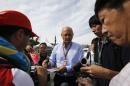 McLaren Formula One Executive Chairman Ron Dennis signs autographs as he arrives for the Japanese F1 Grand Prix at the Suzuka Circuit