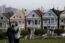 People stop to look at San Francisco's famed Painted Ladies victorian houses on February 18, 2014 in San Francisco, California