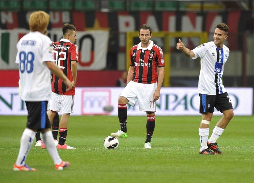 AC Milan's Pazzini reacts as Atalanta's Cigarini celebrates after scoring during their Serie A soccer match at the San Siro stadium in Milan