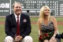 FILE - In this Aug. 3, 2012 file photo, former Boston Red Sox pitcher Curt Schilling sits with his wife Shonda, right, after being introduced as a new member of the Red Sox Hall of Fame before a baseball game between the Red Sox and the Minnesota Twins at Fenway Park in Boston. Schilling, whose video game company collapsed into bankruptcy, is selling off furniture, sports collectibles and even artificial plants from his Massachusetts home. An estate sale company has scheduled a sale of items from Schilling's seven-bedroom, 8,000-square-foot Medfield residence for Saturday, Oct. 12, 2013. (AP Photo/Winslow Townson, File)