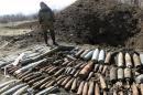 A pro-Russian rebel stands near Ukrainian military unexploded shells at a range in the suburbs of Donetsk