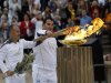 Torchbearers light up a cauldron with the Olympic Flame at the Panathenaic stadium in Athens