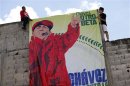 People hang a poster depicting Venezuelan President Hugo Chavez as a rap singer during a boxing tournament at a slum in Los Teques
