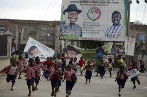 Pupils run past a campaign billboard and banners displayed&nbsp;&hellip;