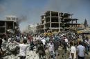 People gather at the site of a bomb attack in the northeastern Syrian city of Qamishli on July 27, 2016 which killed at least 44 people, state media said