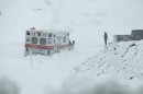 An ambulance is stuck in over a foot of snow off of Highway 33 West, near Belington, W.Va. on Tuesday, Oct. 30, 2012, in Belington, W.Va. Superstorm Sandy buried parts of West Virginia under more than a foot of snow on Tuesday, cutting power to at least 264,000 customers and closing dozens of roads. At least one death was reported. The storm not only hit higher elevations hard as predicted, communities in lower elevations got much more than the dusting of snow forecasters had first thought from a dangerous system that also brought significant rainfall, high wind gusts and small-stream flooding. (AP Photo/Robert Ray)
