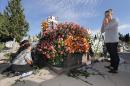 Varias mujeres colocan flores en la tumba de un familiar en el cementerio murciano de Espinardo, ayer. EFE