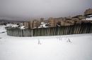 Snow covers the area next to a section of Israel's controversial separation barrier in the West Bank village of Al-Ram on the outskirts of Jerusalem on December 14, 2013
