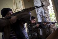 Rebel fighters aim their weapons at regime forces on the front line in the Old City of Aleppo, on December 21, 2012. More than 44,000 people are estimated to have been killed since the eruption in March 2011 of the uprising that morphed into an armed insurgency