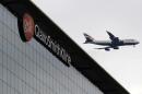 A British Airways airplane flies past a signage for pharmaceutical giant GlaxoSmithKlein in London