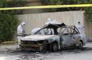 Forensic experts investigate at the scene of a car explosion in the village of al-Maqshaa', west of Manama