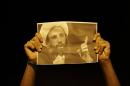 A Bahraini anti-government protester holds up a picture of jailed Saudi Sheik Nimr al-Nimr during clashes with riot police in Sanabis, Bahrain, a suburb of the capital Manama, Wednesday night, Oct. 15, 2014. The well-known Shiite cleric was sentenced to death Wednesday by a court in Saudi Arabia, sparking fears of renewed unrest from his supporters in the kingdom and neighboring Bahrain. (AP Photo/Hasan Jamali)