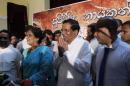 Sri Lankan Health Minister Maithripala Sirisena, center, acknowledges the gathering, with former Sri Lankan president Chandrika Kumaratunge standing by his right, at the end of a press conference in Colombo, Sri Lanka, Friday, Nov. 21, 2014. Sirisena quit President Mahinda Rajapaksa's government Friday to challenge him in the upcoming elections in the most serious setback for the leader's quest for a third term. Sirisena left the government with three other ministers and a lawmaker, saying Friday he has been chosen as the combined opposition's presidential candidate. (AP Photo/Eranga Jayawardena)