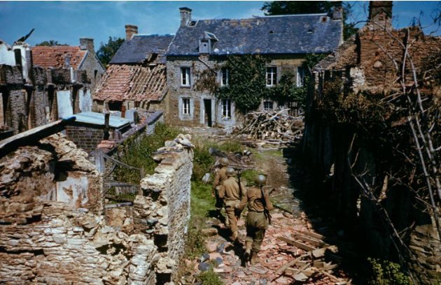 Tentara Amerika Serikat mencari di antara rumah-rumah runtuh di barat Prancis setelah D-Day. (Frank Scherschel—Time & Life Pictures/Getty Images)
