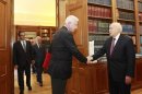 Newly appointed caretaker PM Pikrammenos shakes hands with Greece's President Papoulias during their meeting in Athens