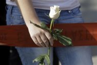 A woman holds a white rose as she stands near the local offices of far-right Golden Dawn party, following last night's shooting, in a northern suburb of Athens November 2, 2013. REUTERS/John Kolesidis