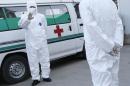 This Monday, Oct. 27, 2014 photo shows medical personnel in protective suits standing by an ambulance, at the Sunan International Airport, in Pyongyang, North Korea. North Korea would seem like the last place on Earth that has anything to worry about from Ebola. But it's virtually gone on DefCon 1 over what it sees as a looming invasion from the outside world that threatens to infiltrate its borders and relentlessly attack its people unless dramatic measures are taken immediately. It has banned tourists, put business groups on hold and is looking even more suspiciously than usual at every foreign face coming across its borders. (AP Photo/Wong Maye-E)