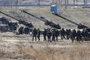 South Korean soldiers walk past Howitzers during an artillery drill as part of the annual joint military exercise by the U.S. and South Korea, near the DMZ which separates the two Korea, in Goseong