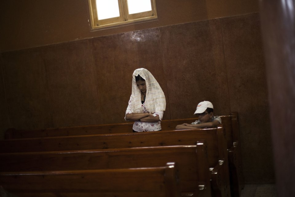 An Egyptian Coptic woman prays in a church within Al-Mahraq Monastery in Assiut, Upper Egypt, Tuesday, Aug. 6, 2013. Islamists may be on the defensive in Cairo, but in Egypt's deep south they still have much sway and audacity: over the past week, they have stepped up a hate campaign against the area's Christians. Blaming the broader Coptic community for the July 3 coup that removed Islamist president Mohammed Morsi, Islamists have marked Christian homes, stores and churches with crosses and threatening graffiti. (AP Photo/Manu Brabo)