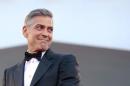 U.S. actor Clooney smiles as he arrives on the red carpet for the premiere of "Gravity" at the 70th Venice Film Festival in Venice