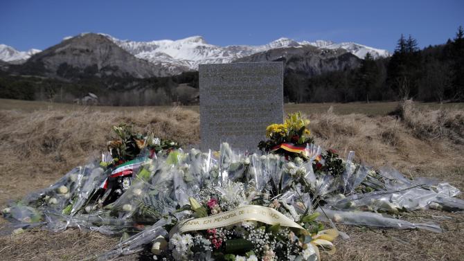 A stele and flowers laid in memory of the victims are placed in the area where the Germanwings jetliner crashed in the French Alps, in Le Vernet, France, Friday, March 27, 2015. The crash of Germanwings Flight 9525 into an Alpine mountain, which killed all 150 people aboard, has raised questions about the mental state of the co-pilot. Authorities believe the 27-year-old German deliberately sought to destroy the Airbus A320 as it flew Tuesday from Barcelona to Duesseldorf. (AP Photo/Christophe Ena)