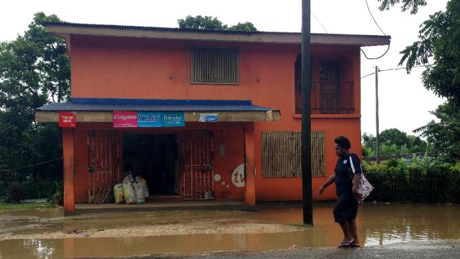 A resident walks along a flooded street caused by Tropical Cyclone Pam, near the Vanuatu capital of Port Vila, on March 13, 2015 in this image by UNICEF Pacific