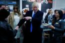 Republican presidential nominee Donald Trump shakes hands with a woman before voting at PS 59 in New York