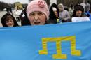Crimean Tatars shout slogans and hold Tatar flag during the pro Ukraine rally in Simferopol, Crimea, Ukraine, Monday, March 10, 2014. Russian President Vladimir Putin on Sunday defended the separatist drive in the disputed Crimean Peninsula as in keeping with international law, but Ukraine's prime minister vowed not to relinquish "a single centimeter" of his country's territory. The local parliament in Crimea has scheduled a referendum for next Sunday. (AP Photo/Darko Vojinovic)