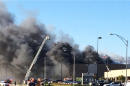 In this photo provided by Jay Boyle, emergency vehicles and first responders are on the scene of a small plane crash at Wichita Mid-Continent Airport in Wichita, Kan., Thursday, Oct. 30, 2014. A small plane lost power after takeoff and crashed into a building while trying to return to a Kansas airport Thursday, killing at least four people. (AP Photo/Jay Boyle)