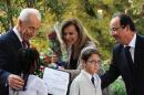 French President Hollande and companion Trierweiler stand next to Israeli President Peres as students from Tel Aviv's Marc Chagall French school welcome them in Jerusalem