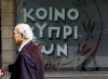 A man and woman, right, walk by a branch of Bank of Cyprus in central Nicosia, Cyprus, Tuesday, March 13, 2012. International ratings agency Moody's downgraded euro member Cyprus into junk status Tuesday on heightened concerns over the exposure of its large banking sector to Greece. The agency reduced its rating on Cyprus by one notch to Ba1 and assigned a negative outlook, meaning that further downgrades are possible. (AP Photo/Petros Karadjias)