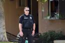 An armed police officer stands guard at a townhome in Redlands, California on December 3, 2015, linked to the December 2 shooting rampage in San Bernardino, California