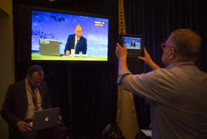 A journalist takes a picture from a TV screen while &hellip;