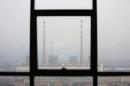 Chimneys are seen through a window at a coal-fired power plant on a hazy day in Shimen county