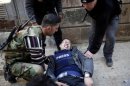 Ayman al-Sahili, a Reuters cameraman, reacts as he was shot in the leg while filming on the front line in Syria's north city of Aleppo by a sniper loyal to Syrian President Bashar el-Assad