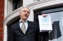 WikiLeaks founder Julian Assange addresses the media holding a printed report of the judgement of the UN's Working Group on Arbitrary Detention on his case from the balcony of the Ecuadorian embassy in central London on February 5, 2016