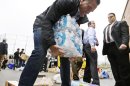 Republican presidential candidate, former Massachusetts Gov. Mitt Romney lifts bottles of water to load into a truck as he participates in a campaign event collecting supplies from residents and local relief organizations for victims of superstorm Sandy,Tuesday, Oct. 30, 2012, at the James S. Trent Arena in Kettering, Ohio. (AP Photo/Charles Dharapak)