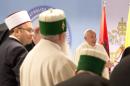 Pope Francis, right, arrives for a meeting with representatives of Albania's Muslim, Orthodox and Catholic communities, at the Catholic University "Our Lady of Good Counsel" in Tirana, Sunday, Sept. 21, 2014. Pope Francis has called on moderate Muslims and all religious leaders to condemn Islamic extremists who "pervert" religion to justify violence, as he visited Albania and held it up as a model for interfaith harmony. One of the highlights of Francis' visit was a meeting Sunday with representatives of Albania's Muslim, Orthodox and Catholic communities, which all suffered persecution under communism but now live and work together peacefully. (AP Photo/Alessandra Tarantino,Pool)