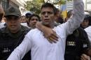 Leopoldo Lopez, an ardent opponent of Venezuela's socialist government, is escorted by the National Guard after turning himself in during a demonstration in Caracas on February 18, 2014