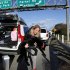 Heidi Blood carries her dog to the side of the road for a drink of water while waiting in line with her car along Interstate 5 north of Los Angeles on Friday, Jan. 11, 2013. The California Highway Patrol has partially reopened a 40-mile stretch of Interstate 5 north of Los Angeles that was closed for many hours due to snow. The CHP began escorting southbound motorists through the high mountain pass Friday morning. Northbound lanes are still closed. (AP Photo/Nick Ut)