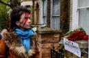 A woman pays her respects outside a house, believed to be the childhood home of British singer David Bowie, following the announcement of Bowie's death, in Brixton, south London, on January 11, 2016
