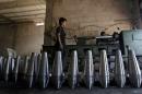 Rebel fighters make improvised mortar shells inside a weapons factory in Idlib