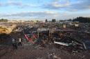 Rescuers search amid the debris left by a huge blast that occured in a fireworks market in Mexico City, on December 20, 2016 killing at least nine people and injuring 70, according to police