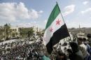Men carry a Free Syrian Army flag while attending an anti-government protest in Maarat al-Numan