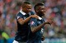 France's Paul Pogba, right, celebrates after scoring with his teammate Patrice Evra, during their international friendly soccer match against Portugal, at the Stade de France, in Saint Denis, north of Paris, France, Saturday, Oct. 11, 2014. (AP Photo/Thibault Camus)