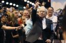 Berkshire Hathaway CEO Buffett points after throwing a newspaper during a competition at a trade show, at the company's annual meeting in Omaha