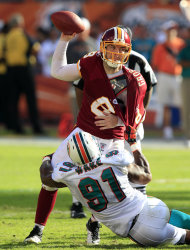 El quarterback de los Redskins de Washington Rex Grossman es asediado por el linebacker de los Dolphins de Miami Cameron Wake el domingo 13 de noviembre de 2011. (AP Foto/Wilfredo Lee)