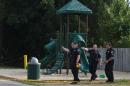 Kentwood police investigate a stabbing that occurred in a playground in Pinebrook Village, in Kentwood, Mich., on Aug. 4, 2014. Police say a 12-year-old boy has stabbed a 9-year-old boy at the playground in western Michigan, sending the child to a hospital. Police also didn't immediately release detail on the condition of the wounded child. The older boy was taken into custody for questioning by police. (AP Photo/The Grand Rapids Press, Joel Bissell) ALL LOCAL TELEVISION OUT; LOCAL TELEVISION INTERNET OUT
