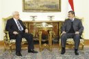 Palestinian President Mahmoud Abbas talks with Egyptian President Mohammed Mursi during their meeting in Cairo in this picture provided by the Egyptian Presidency
